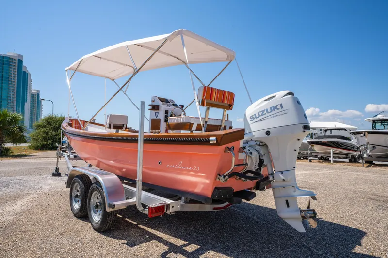 Slide: The Image of 2025 Caribiana Maracas 23 Skiff with Suzuki engine on trailer, sunny day, urban background. - 11