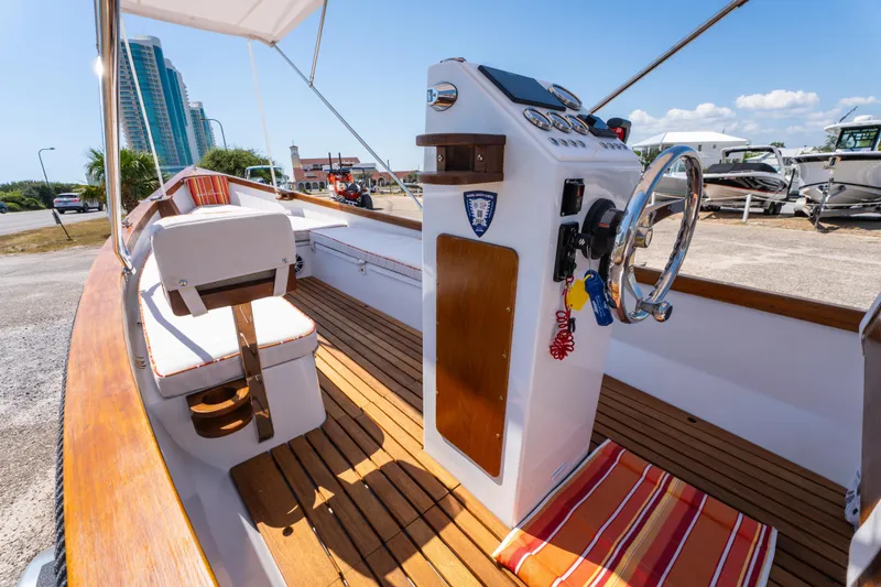 Slide: The Image of 2025 Caribiana Maracas 23 Skiff interior with wooden deck and modern steering console. - 14