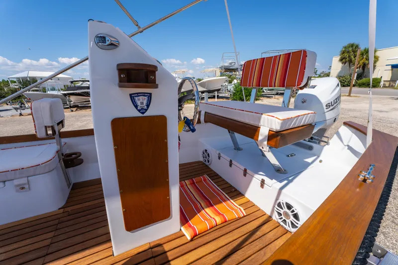 Slide: The Image of 2025 Caribiana Maracas 23 Skiff interior with striped seating and wooden deck. - 17