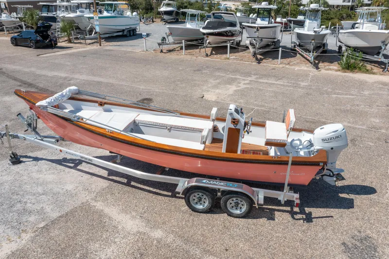 Slide: The Image of 2025 Caribiana Maracas 23 Skiff on trailer, parked in a boatyard. - 2