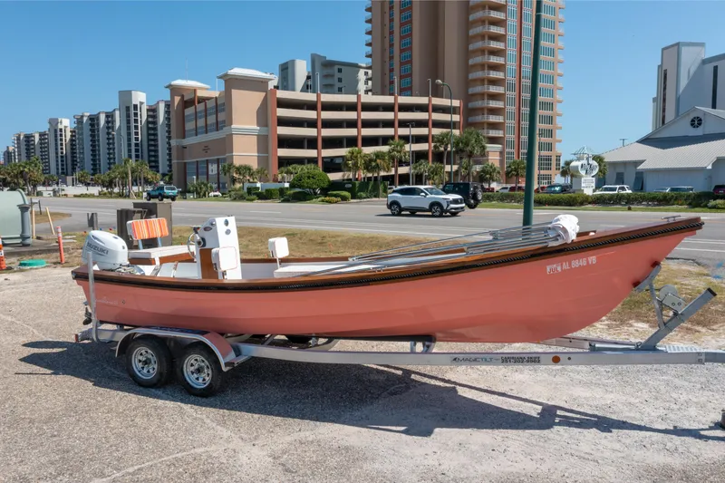 Slide: The Image of 2025 Caribiana Maracas 23 Skiff on trailer, urban background, sunny day. - 6