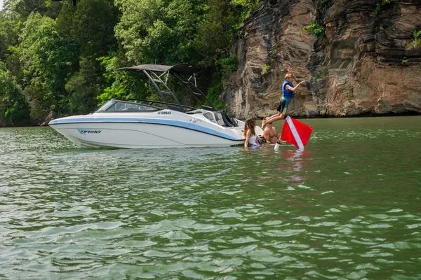 Slide: The Image of 2026 Yamaha AR190 boat near rocky shoreline with people swimming and diving. - 5