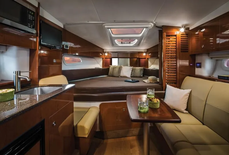 Slide: The Image of 2015 Sea Ray 310 Sundancer boat interior with seating and wooden table. - 83