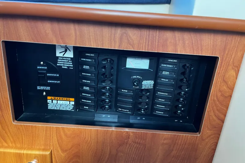 Slide: The Image of Electrical control panel on a 2008 Bayliner 320 boat, featuring various switches and gauges. - 13