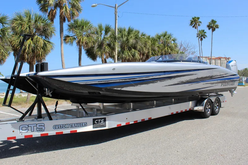 Slide: The Image of 2025 Fountain 34 Thundercat boat on trailer, parked near palm trees and ocean. - 3