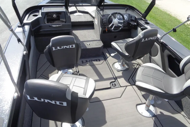 Slide: The Image of 2026 Lund 1875 Crossover XS boat interior with four swivel seats and modern dashboard. - 12
