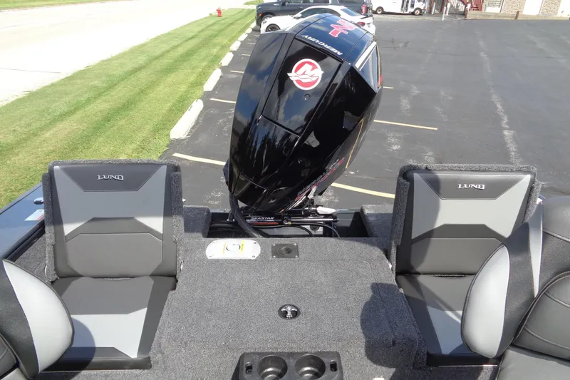 Slide: The Image of 2026 Lund 1875 Crossover XS boat with Mercury outboard engine, parked on asphalt. - 13