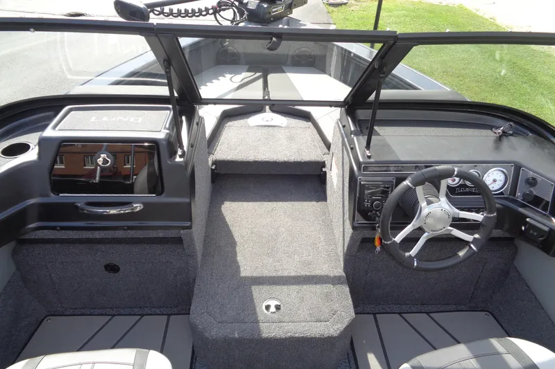 Slide: The Image of 2026 Lund 1875 Crossover XS boat interior with steering wheel and dashboard controls. - 14