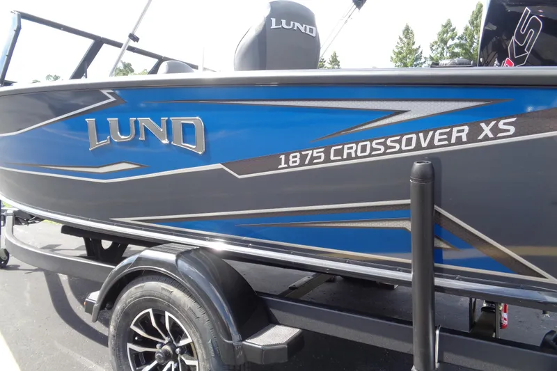 Slide: The Image of 2026 Lund 1875 Crossover XS boat, blue and gray design, on trailer. - 3