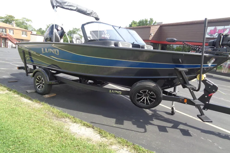 Slide: The Image of 2026 Lund 1875 Crossover XS boat on trailer, parked outdoors. - 8