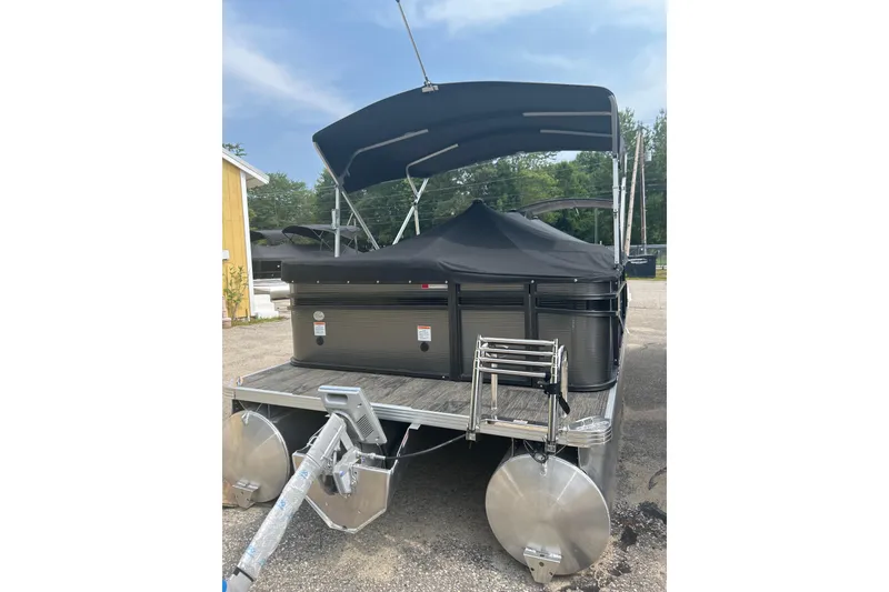 Slide: The Image of 2023 Crest Current pontoon boat with canopy and trailer, parked outdoors. - 7