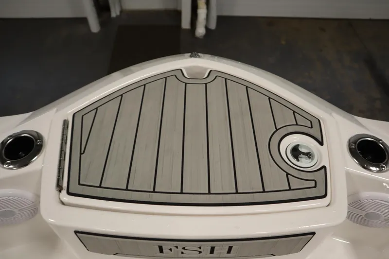 Slide: The Image of 2026 Yamaha Boats 220 FSH Sport deck with storage compartment and cup holders. - 11