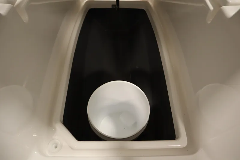 Slide: The Image of 2026 Yamaha Boats 220 FSH Sport interior compartment with a white bucket. - 17