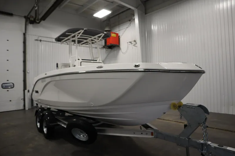 Slide: The Image of 2026 Yamaha Boats 220 FSH Sport in a showroom, on a trailer. - 2