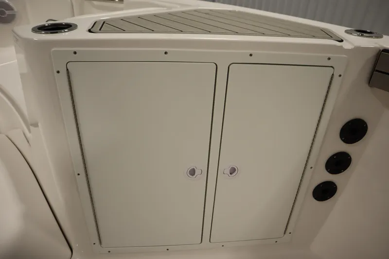 Slide: The Image of 2026 Yamaha Boats 220 FSH Sport storage compartment with cup holders and sleek design. - 21