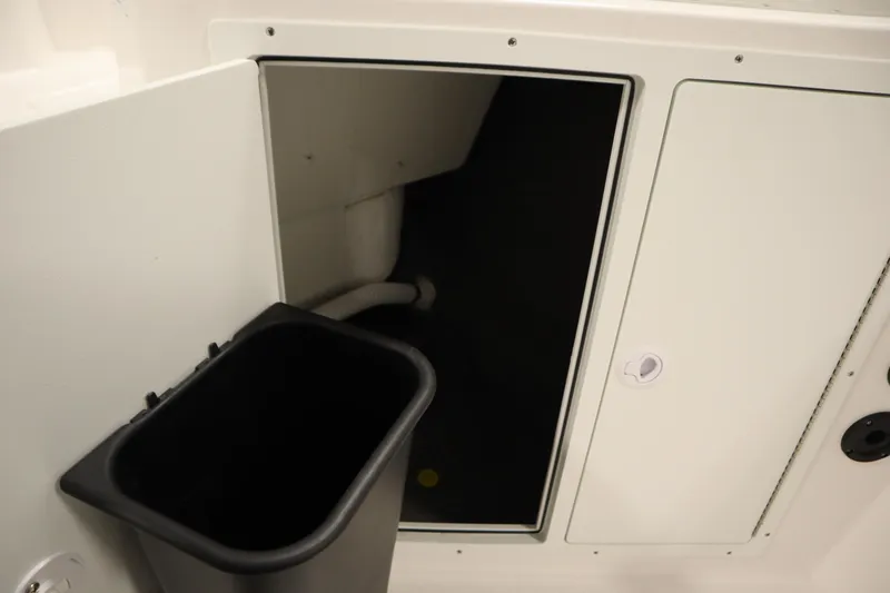 Slide: The Image of Storage compartment on 2026 Yamaha Boats 220 FSH Sport, featuring a black bin. - 22