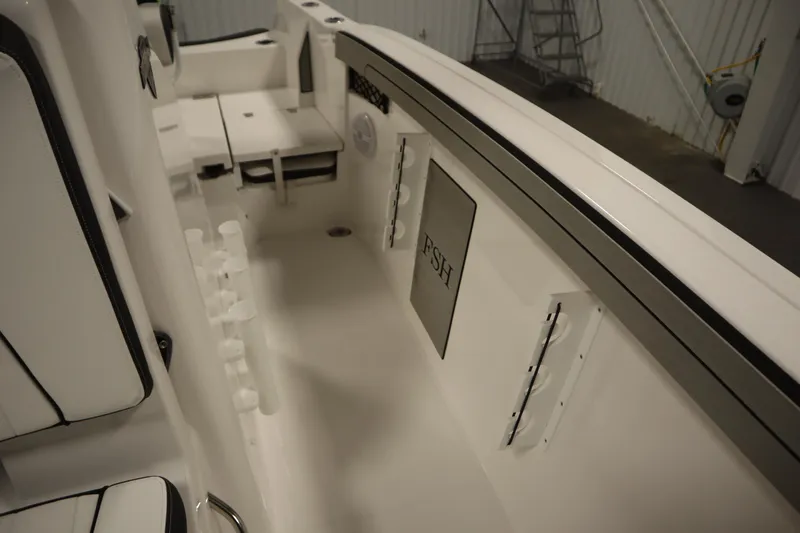 Slide: The Image of 2026 Yamaha Boats 220 FSH Sport interior, featuring fishing rod holders and seating. - 25