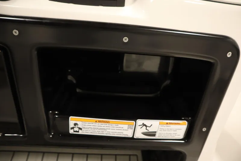 Slide: The Image of 2026 Yamaha Boats 220 FSH Sport storage compartment with safety warning labels. - 35
