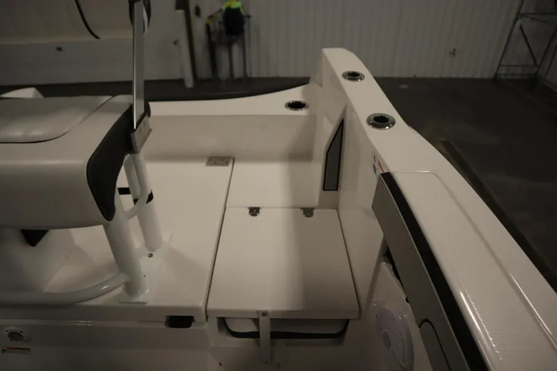 Slide: The Image of 2026 Yamaha Boats 220 FSH Sport interior seating and storage area in a showroom. - 38
