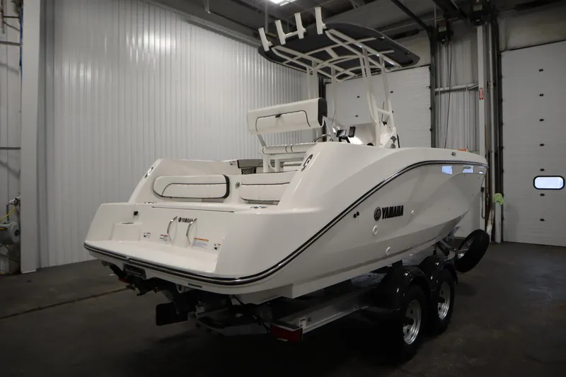 Slide: The Image of 2026 Yamaha Boats 220 FSH Sport in a garage, rear view. - 4