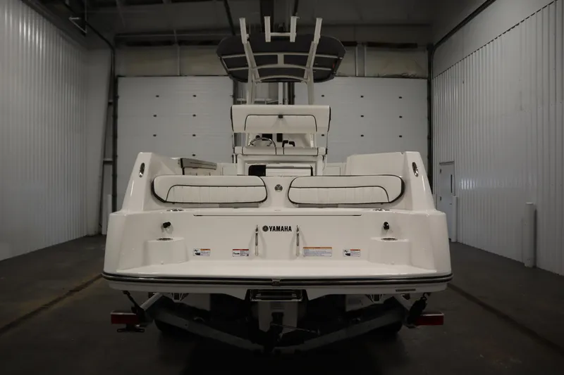 Slide: The Image of 2026 Yamaha Boats 220 FSH Sport in a garage, rear view. - 5
