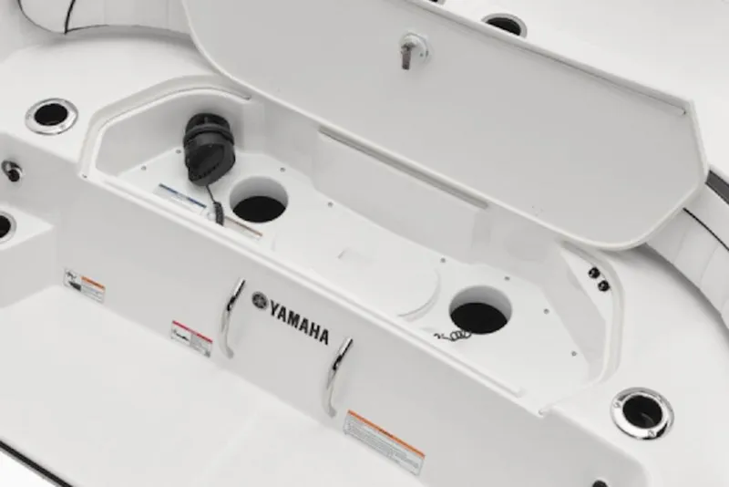 Slide: The Image of 2026 Yamaha Boats 220 FSH Sport storage compartment with open lid and cup holders. - 51