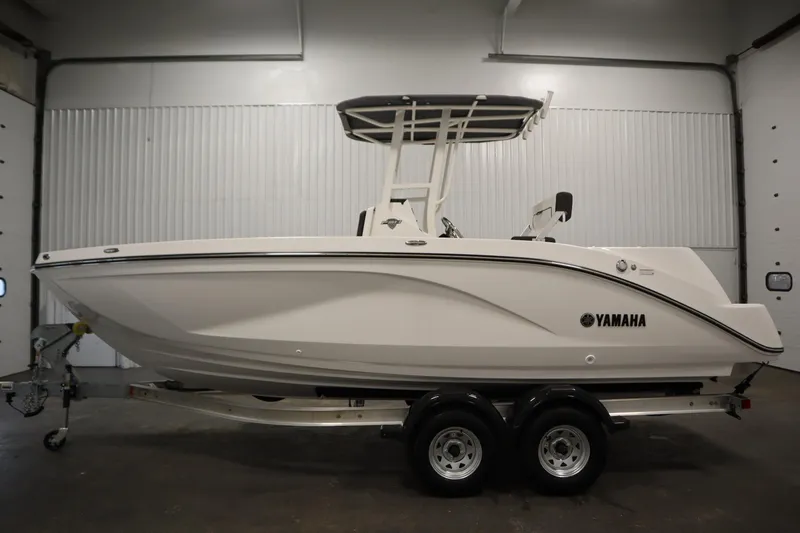 Slide: The Image of 2026 Yamaha Boats 220 FSH Sport in a showroom, side view on trailer. - 7