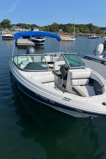 Slide: The Image of 2019 Regal 21 OBX boat docked in a marina with blue canopy. - 10