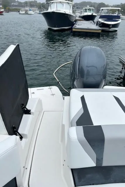 Slide: The Image of 2019 Regal 21 OBX boat docked, featuring sleek seating and outboard motor. - 14