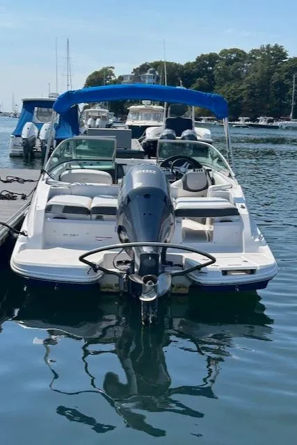 Slide: The Image of 2019 Regal 21 OBX boat docked with blue canopy and outboard motor. - 8