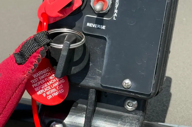 Slide: The Image of Key ignition and safety lanyard on 2025 Alweld 1548 Invader boat control panel. - 14