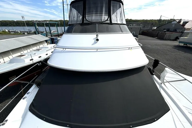 Slide: The Image of 2003 Carver 396 Motor Yacht docked, showcasing sleek design and spacious deck. - 16