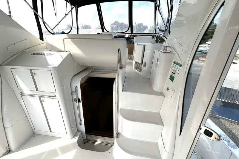 Slide: The Image of 2003 Carver 396 Motor Yacht interior with stairs and cabinetry, featuring sleek white design. - 19