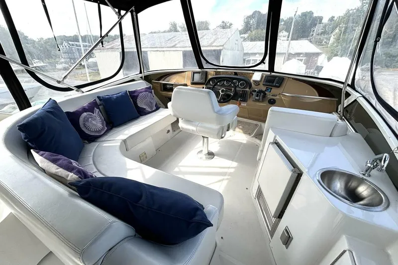 Slide: The Image of 2003 Carver 396 Motor Yacht interior with plush seating, helm, and kitchenette. - 20