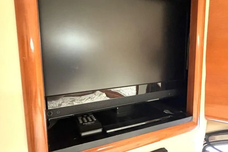 Slide: The Image of Flat-screen TV and remote in 2003 Carver 396 Motor Yacht interior. - 38