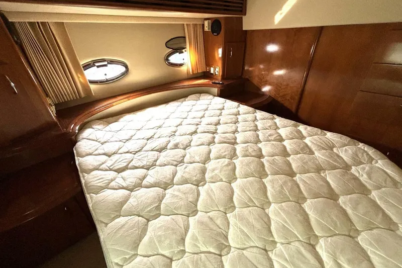 Slide: The Image of Luxurious bedroom interior of 2003 Carver 396 Motor Yacht with plush bedding and porthole windows. - 44