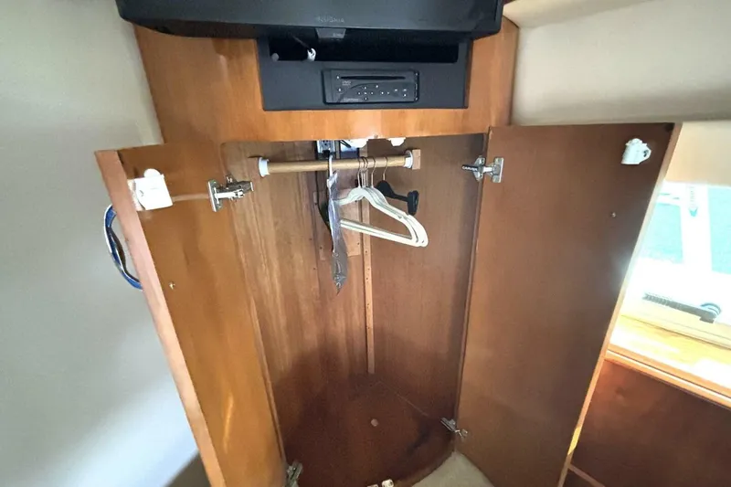 Slide: The Image of Open wooden closet with hangers inside a 2003 Carver 396 Motor Yacht. - 47