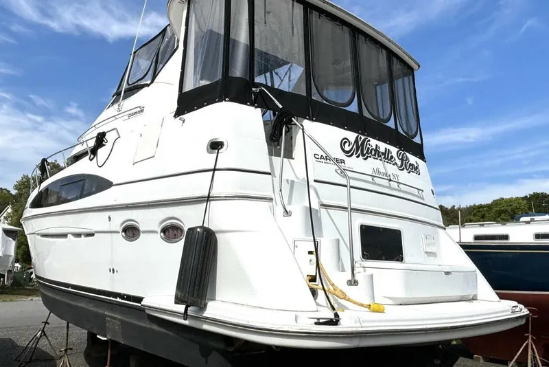 Slide: The Image of 2003 Carver 396 Motor Yacht on land, featuring sleek design and spacious cabin. - 5
