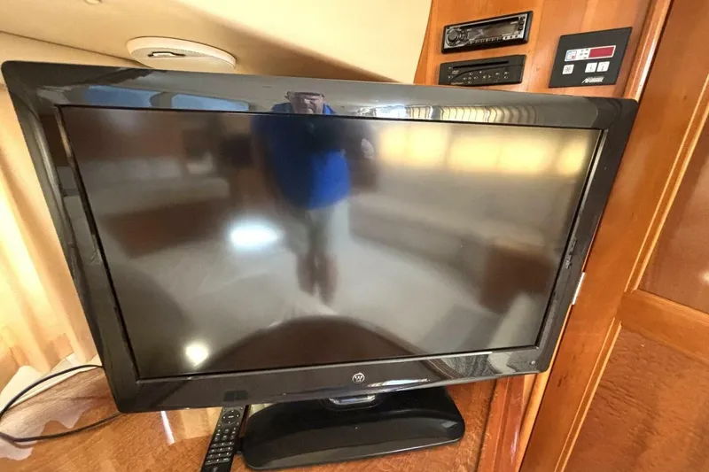 Slide: The Image of Flat-screen TV inside 2003 Carver 396 Motor Yacht, with remote and control panel. - 32