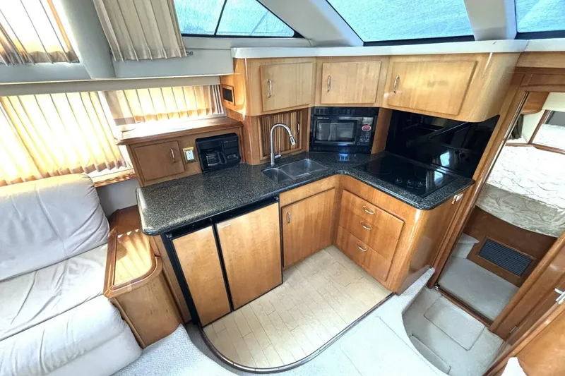 Slide: The Image of 2003 Carver 396 Motor Yacht interior kitchen with wood cabinetry and modern appliances. - 34