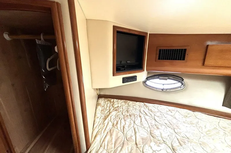 Slide: The Image of 2003 Carver 396 Motor Yacht interior with bed, closet, and porthole window. - 37