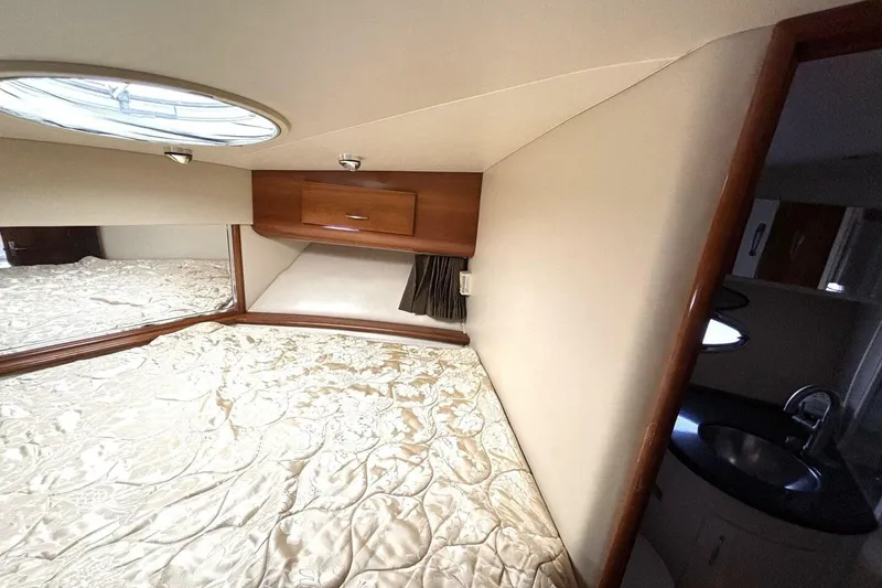 Slide: The Image of 2003 Carver 396 Motor Yacht bedroom with elegant bedding and wooden cabinetry. - 39