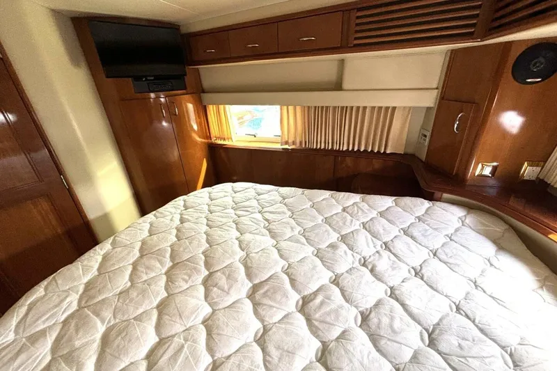Slide: The Image of Luxurious bedroom interior of 2003 Carver 396 Motor Yacht with wood accents and cozy bedding. - 45