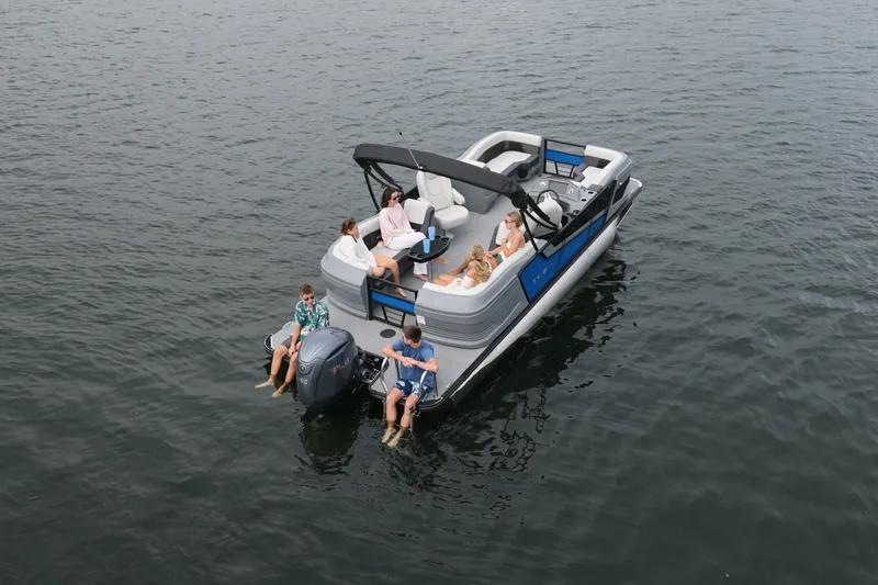 Slide: The Image of Sylvan R22 LZ DH 2026 pontoon boat on calm water with passengers. - 2