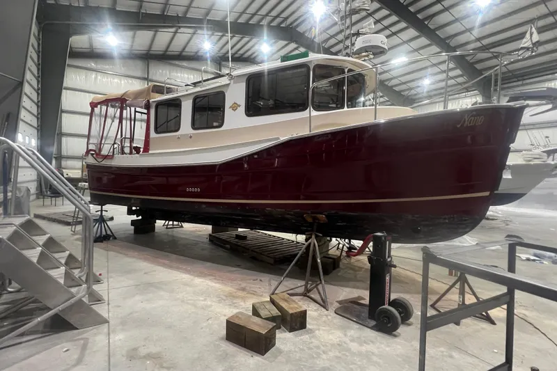 The Image of 2017 Ranger Tugs R-27 Tug in a warehouse, elevated on supports. - 0