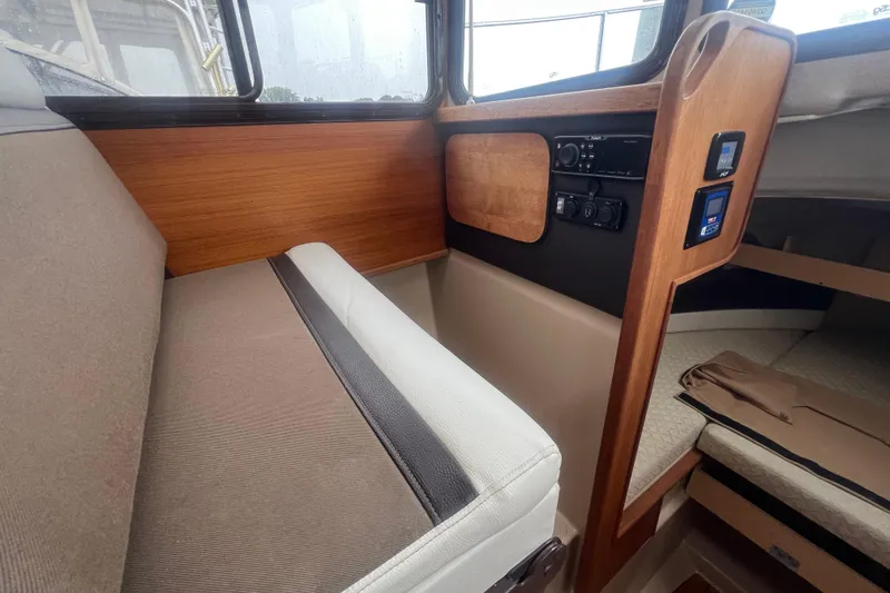 Slide: The Image of Interior of 2017 Ranger Tugs R-27 Tug, featuring seating and control panel. - 11