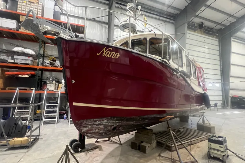 Slide: The Image of 2017 Ranger Tugs R-27 Tugboat "Nano" in a warehouse, elevated on stands. - 26