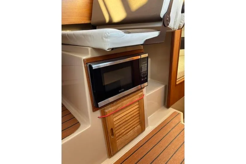 Slide: The Image of 2017 Ranger Tugs R-27 Tug interior with microwave and wooden cabinetry. - 4