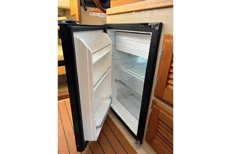 Slide: The Image of Open refrigerator inside 2017 Ranger Tugs R-27 Tug, showcasing interior shelves and storage. - 6