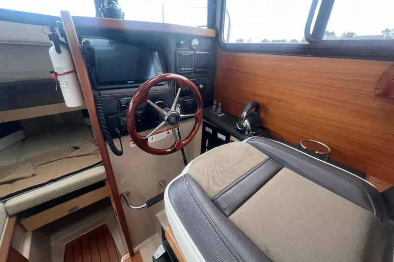 Slide: The Image of 2017 Ranger Tugs R-27 Tug interior with steering wheel and navigation equipment. - 12